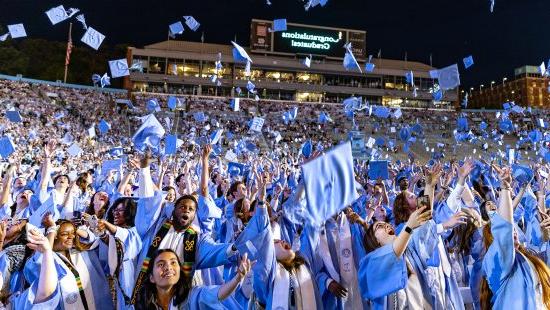 Carolina graduates throw their caps in the air at Spring Commencement in May 2024.