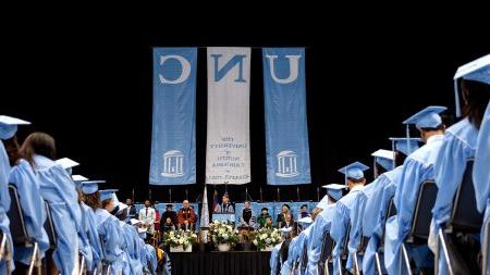 Rows of graduates seen sitting and listening to Chancellor Lee H. Roberts speak at U.N.C. Chapel Hill's Winter Commencement.